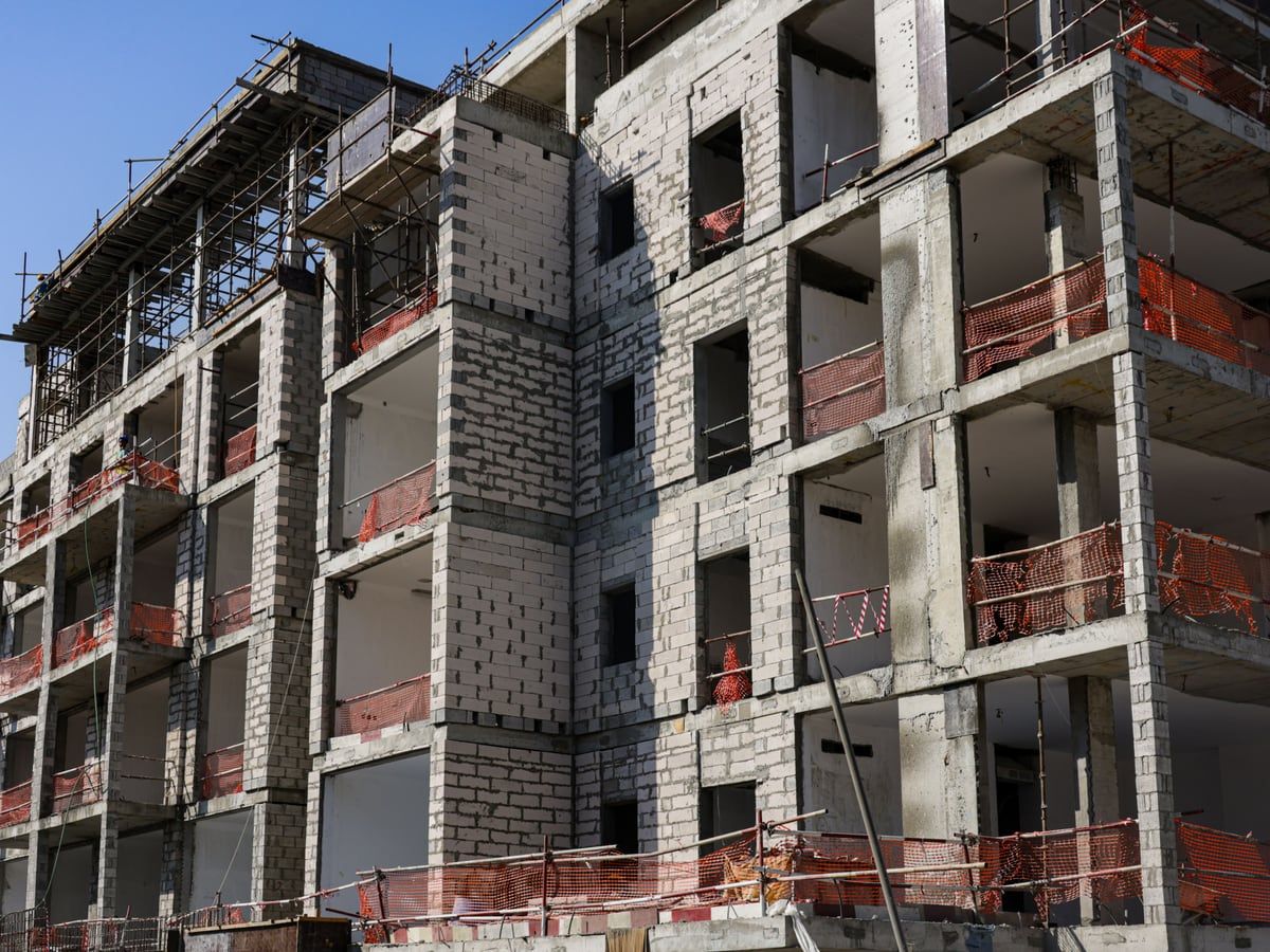 Rohbau eines mehrgeschossigen Wohngebäudes mit Gerüst und offenen Fensteröffnungen